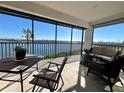 Enjoy serene water views from this screened lanai with comfortable seating and a dining table at 3630 Gulf Of Mexico Dr # 304, Longboat Key, FL 34228