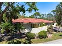 Low angle exterior view with red tile roof, landscaping, and a driveway leading to the garage at 3804 Sun Eagle Ln, Bradenton, FL 34210