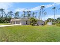 Home with a neatly kept lawn, and lush trees on a sunny day at 3865 N Cranberry Blvd, North Port, FL 34286