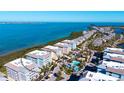 Stunning aerial view of a coastal community with multiple condo buildings, a pool, and easy access to the ocean at 388 Aruba Cir # 201, Bradenton, FL 34209