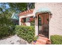 Charming home entrance with coral stucco, terra cotta tile, and lush greenery enhancing curb appeal at 401 27Th W St, Bradenton, FL 34205