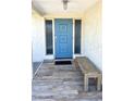 Inviting front entrance featuring a vibrant blue door and bench seating on a tiled porch at 41 Young Ave, Englewood, FL 34223