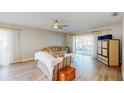 Comfortable living room with wood floors, ceiling fan, sliding glass doors, and neutral color palette at 4201 Center Gate Ln # 1, Sarasota, FL 34233