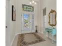 Inviting foyer with high ceilings, decorative glass above the door, and an attractive accent table with mirror at 5311 72Nd E St, Palmetto, FL 34221