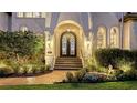 Grand entrance featuring a wrought iron door, manicured landscaping, and brick stairs at 551 Ranger Ln, Longboat Key, FL 34228