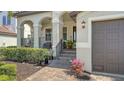 Inviting front porch with stone steps, wrought iron railing, and tropical landscaping at 5723 Title Row Dr, Bradenton, FL 34210