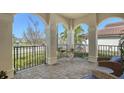 Cozy front porch with brick flooring, comfortable seating, and wrought iron railing at 5723 Title Row Dr, Bradenton, FL 34210
