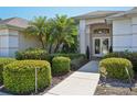 Elegant double door entry framed by well-maintained shrubs and decorative foliage at 610 147Th St E, Bradenton, FL 34212