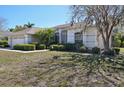 Well-manicured lawn and shrubbery surround this single-story home with a side-entry garage at 610 147Th St E, Bradenton, FL 34212