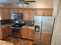 Modern kitchen featuring stainless steel appliances, granite countertops, and wooden cabinets at 6403 Heritage Ln # 6403, Bradenton, FL 34209