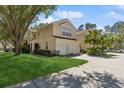 Light yellow townhome featuring an attached garage and a lush green lawn at 6412 Rosefinch Ct # 102, Lakewood Ranch, FL 34202