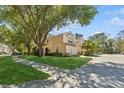 Charming light yellow townhome with a well-manicured lawn and mature shade trees at 6412 Rosefinch Ct # 102, Lakewood Ranch, FL 34202