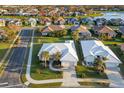 An aerial view of a community with well-maintained lawns and white roofs, near a lake at 664 Silk Oak Dr, Venice, FL 34293