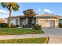 Inviting home with a well manicured lawn, beautiful landscaping, and a two-car garage at 664 Silk Oak Dr, Venice, FL 34293
