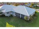 An aerial view of a screened in lanai, with a well maintained lawn at 664 Silk Oak Dr, Venice, FL 34293