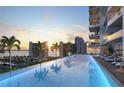 Gorgeous waterfront infinity pool with comfortable lounge chairs and beautiful sunset views at 668 Quay Commons # 1401, Sarasota, FL 34236
