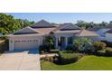 Charming single-story home featuring a well-manicured lawn and two-car garage at 711 Planters Manor Way, Bradenton, FL 34212