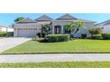 Attractive home with a spacious front lawn, mature trees, and a welcoming entrance at 711 Planters Manor Way, Bradenton, FL 34212