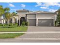 Charming single-story home with a tile roof, arched entry, three-car garage and well-manicured landscaping at 8016 Grande Shores Dr, Sarasota, FL 34240