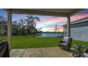 Enjoy peaceful lake views from this backyard patio with cozy seating at sunset at 8918 Waxwing Way, Parrish, FL 34219