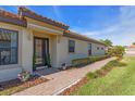 Inviting front entrance with an elegant glass door, tiled roof overhang, and lush landscaping leading to the walkway at 10230 Highland Park Pl, Palmetto, FL 34221