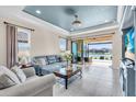 Bright living room with lake views, tile flooring, comfortable sofas, and access to a screened lanai at 10230 Highland Park Pl, Palmetto, FL 34221