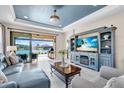 Cozy living room featuring a beautiful lake view, comfortable seating, and a stylish blue entertainment center at 10230 Highland Park Pl, Palmetto, FL 34221