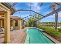 Screened-in pool with brick paver deck and serene water views, perfect for relaxation at 12711 Del Corso Loop, Bradenton, FL 34211