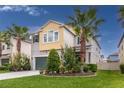 A charming two-story home with lush landscaping and well-manicured lawn featuring palm trees at 1570 Ludington Ave, Wesley Chapel, FL 33543