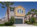 Two-story home with yellow accent featuring a well-manicured lawn and beautiful tropical landscaping at 1570 Ludington Ave, Wesley Chapel, FL 33543
