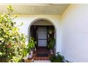 Inviting arched front entrance adorned with greenery and decorative accents at 18422 Burkholder Cir, Port Charlotte, FL 33948