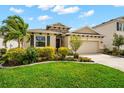 Beautiful one-story home featuring a well-maintained lawn, vibrant landscaping, and an attached garage at 2259 Midnight Pearl Dr, Sarasota, FL 34240