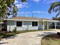 Quaint single-story home with a well-kept lawn, an inviting driveway, and a convenient carport at 2885 Poplar St, Sarasota, FL 34237