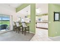 Open-concept kitchen features a breakfast bar with seating, white cabinetry, and a seamless flow to outdoor spaces at 2912 Fiddlers Bnd, Palmetto, FL 34221