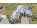 Beautiful aerial view showcasing the home's metal roof, brick driveway, and well-manicured landscaping at 29527 Leah Rd, Punta Gorda, FL 33982