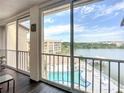 Balcony view overlooking a pool and a lake, enhancing the appeal of outdoor living and relaxation at 3821 Lake Bayshore Dr # H-507, Bradenton, FL 34205
