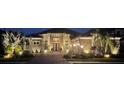 Exterior night shot of home featuring stone facade and manicured landscaping with accent lighting at 5313 Greenbrook Dr, Sarasota, FL 34238
