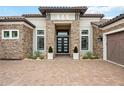 Close-up view of home showcasing stone accents, a tile roof, brick driveway, and manicured landscaping that create curb appeal at 5313 Greenbrook Dr, Sarasota, FL 34238