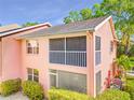 Rear exterior featuring screened balcony, well maintained stucco and mature surrounding landscaping at 5500 Longwood Run Blvd # 201, Sarasota, FL 34243