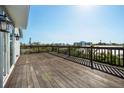 Spacious wooden deck with railing, offering stunning views of the surrounding cityscape and clear blue skies at 5512 Avenida Del Mare, Sarasota, FL 34242