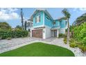 Beautiful two-story home with a paver driveway, manicured lawn and a striking blue facade at 5930 Briarwood Ave, Sarasota, FL 34231
