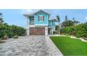 Two-story home with a paver driveway and manicured lawn, showcasing the home's charming curb appeal at 5930 Briarwood Ave, Sarasota, FL 34231