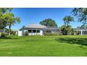 Expansive backyard featuring lush green grass and a screened lanai, perfect for outdoor living at 626 Magellan Dr, Sarasota, FL 34243
