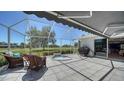 Relaxing screened lanai featuring a hot tub, comfortable seating, and retractable awning at 626 Magellan Dr, Sarasota, FL 34243