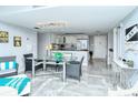Open dining area featuring a glass table, wicker chairs, and views of the living room at 6415 Midnight Pass Rd # 607, Sarasota, FL 34242