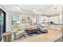 Bright living room featuring modern furnishings, wood floors, and a view into the kitchen at 6492 Positano Ct, Sarasota, FL 34243