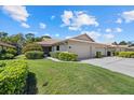 Charming home with manicured lawn, mature landscaping, and attached garages at 7205 Wood Creek Dr # 16, Sarasota, FL 34231