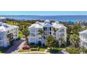 Luxury condominium building features stunning waterfront views, a white metal roof, and lush landscaping at 7810 34Th W Ave # 103, Bradenton, FL 34209