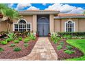 Inviting front entrance with double doors, brick walkway, and colorful landscaping at 8449 Lone Eagle Way, Sarasota, FL 34241