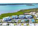 Aerial view of condos with a shared pool, tennis court, and lush green landscaping near the water at 9203 Griggs Rd # B102, Englewood, FL 34224